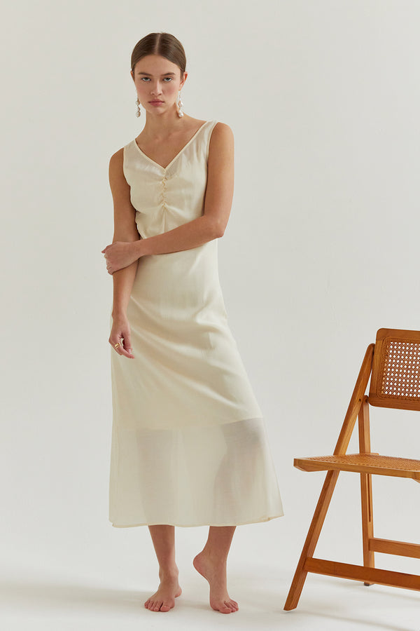 a model in a cream midi dress with a v-neckline