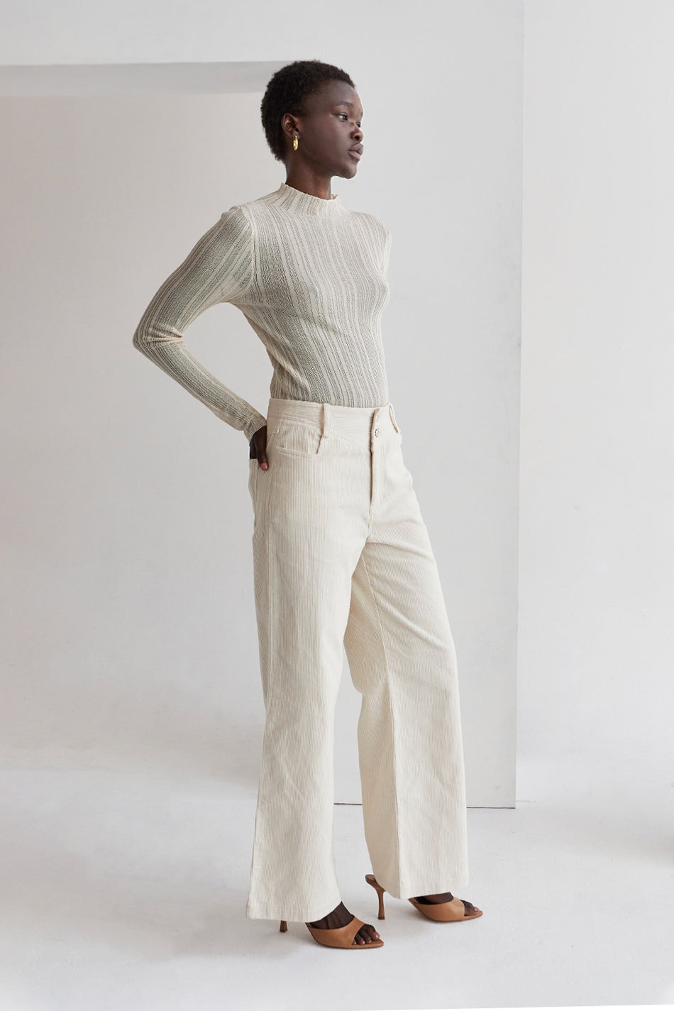 model wearing a neutral knit top with cream corduroy pants