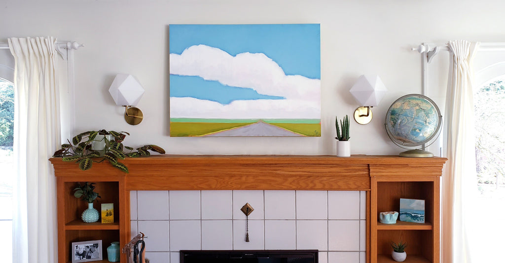 Graphic landscape painting over fireplace