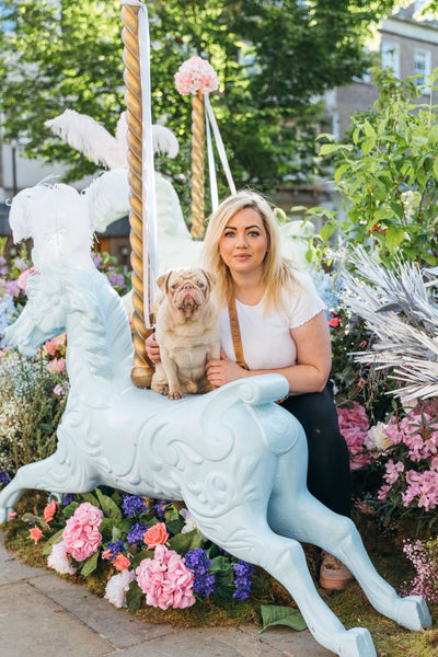 Milkshake the Pug and his owner posing for cameras at Chelsea in Bloom 2023