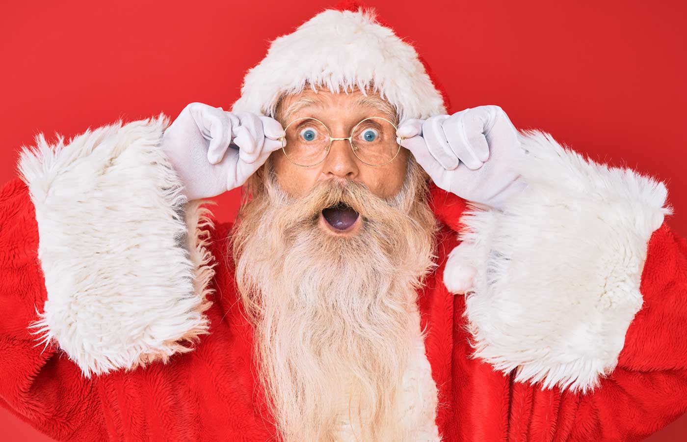 image of Santa Claus pulling a face in front of a red background
