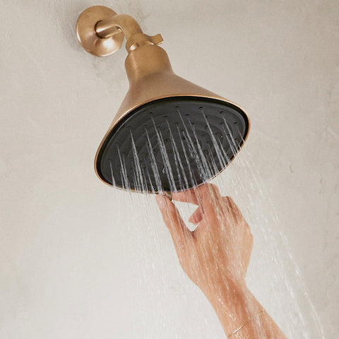 Hand operating Canopy's brass showerhead