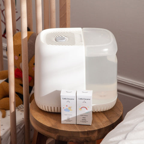 White Nursery Humidifier with Little Dreams Aroma Kit next to a crib