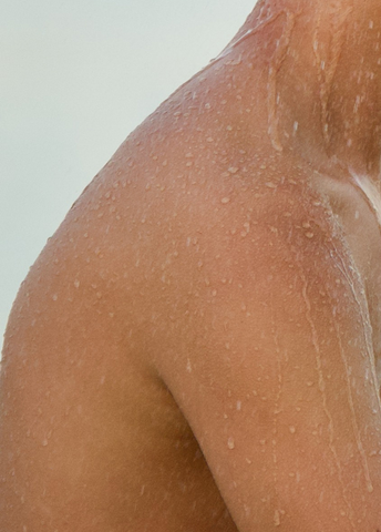 Wet skin on the neck and shoulder of a person showering