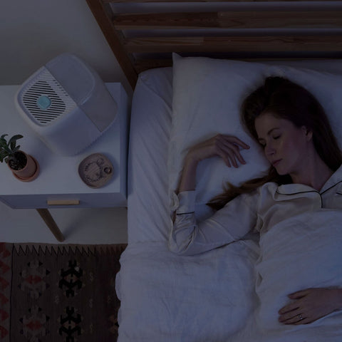 Woman sleeping next to a Canopy Bedside Humidifier at night