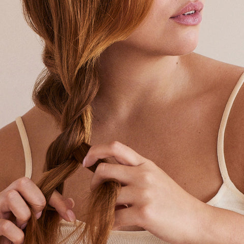 Woman braiding red hair