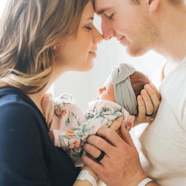 Parents snuggling on their new baby girl