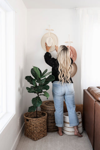 model taking hat out of wall mounted hat display