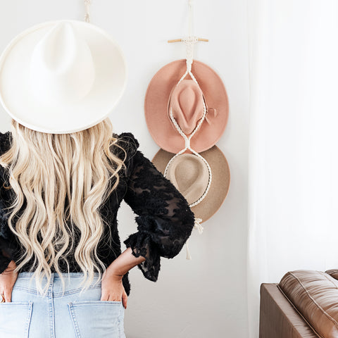 model with hat looking at double hat wall display 