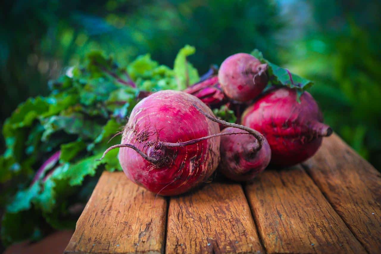 several beetroots sitting on a brown table outside