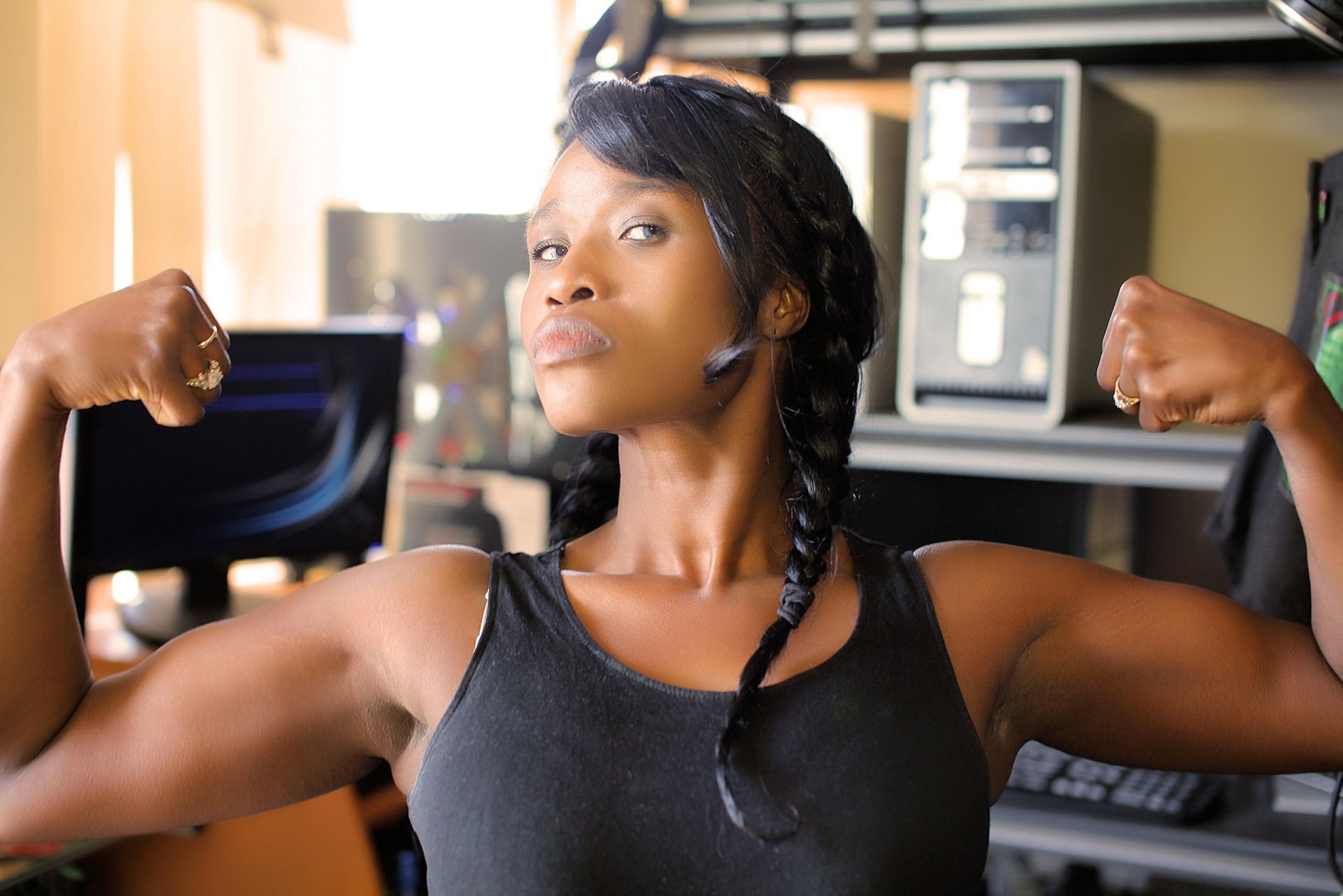 A woman with pronounced arm muscles flexing at the camera. 