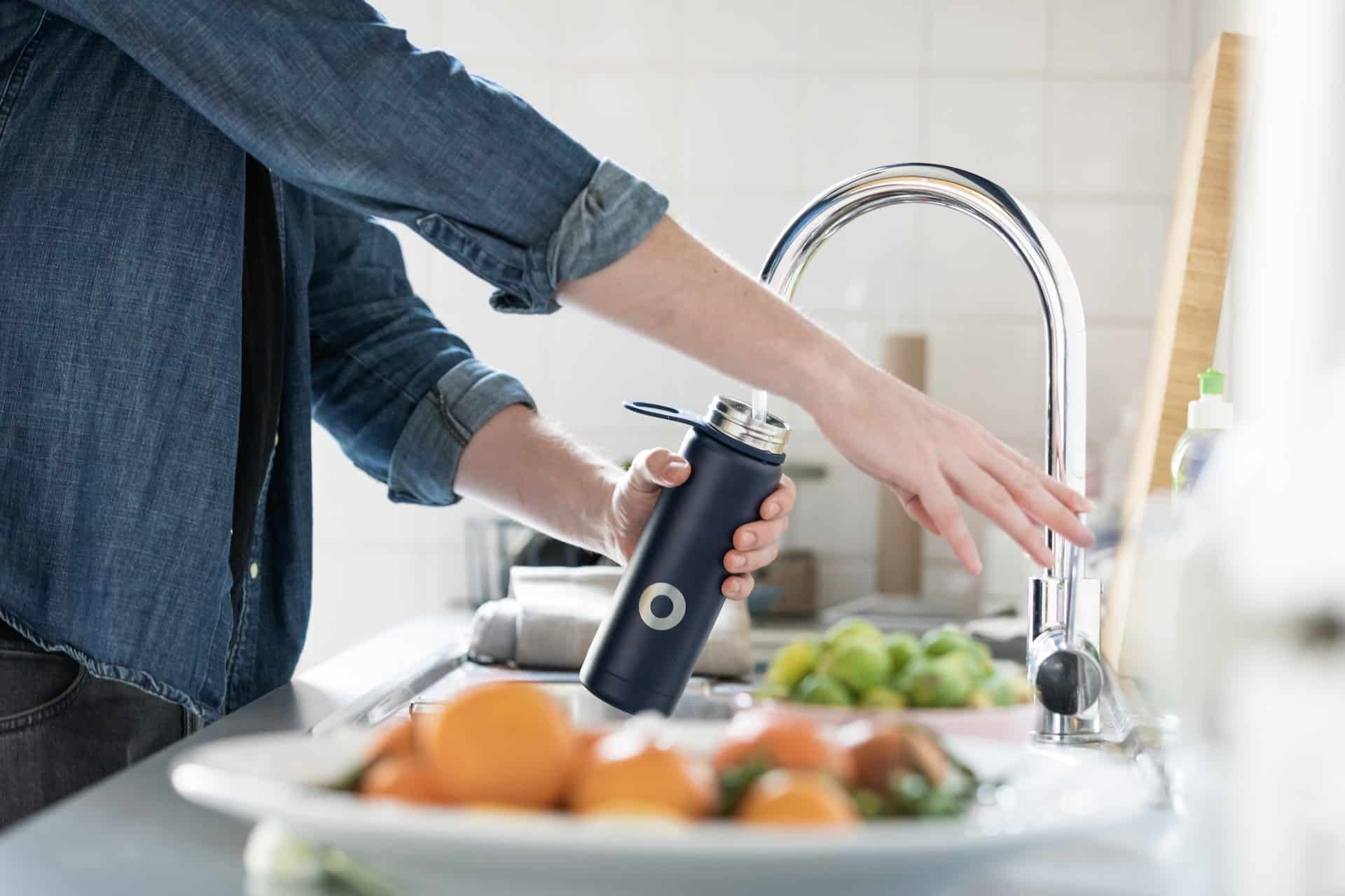 Person filling up a bottle of water