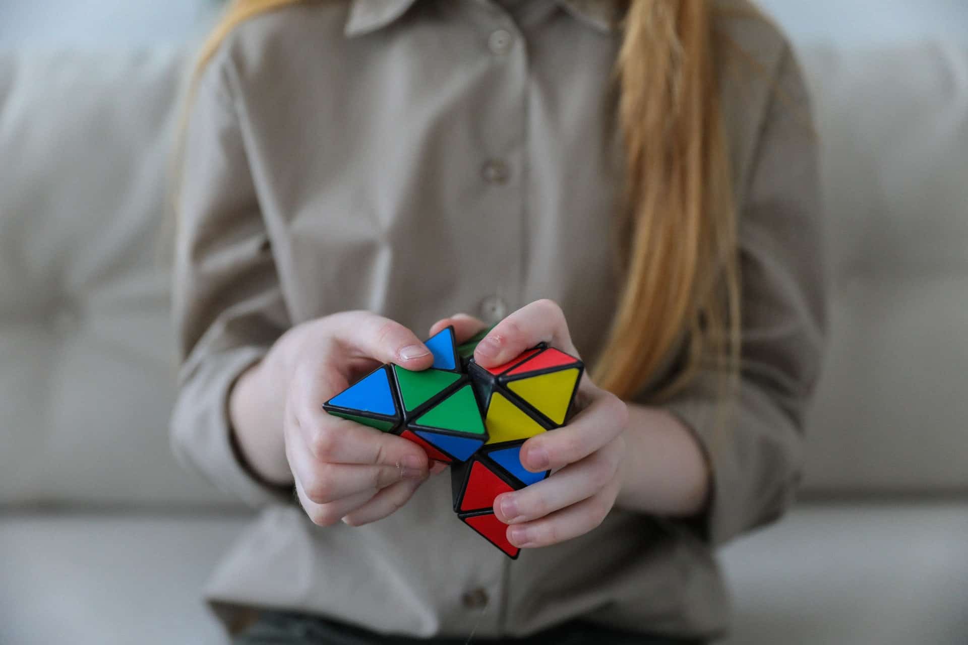 A woman solving a colorful 3D puzzle. 