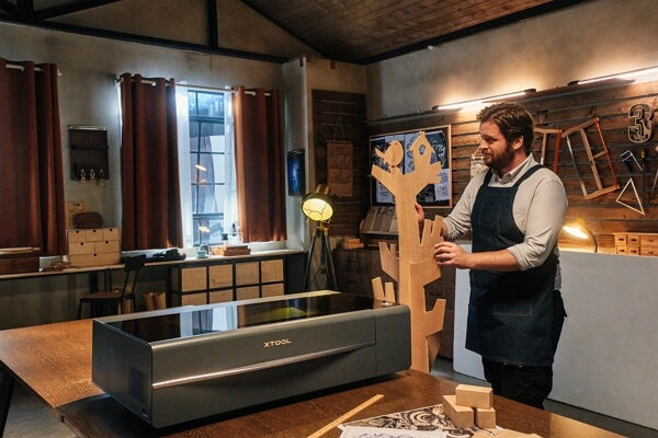 a woodworker making a wood project using a laser cutter