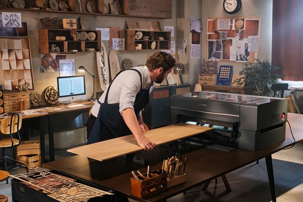 a woodworker handling a laser cutting machine