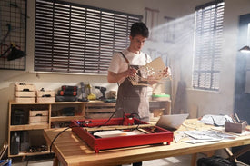 a man making wooden anniversary gifts using a laser cutter