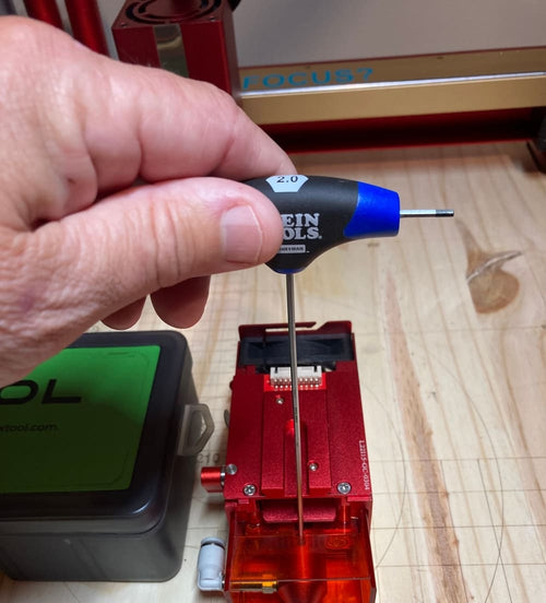 using a 2mm allen wrench to remove the nozzle assembly to clean the laser lens