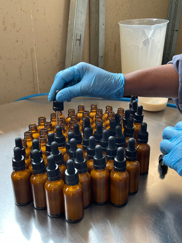 Production team filling and packaging serum bottles | Standard Beauty