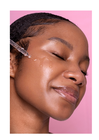 Black model applying serum to her face | Standard Beauty 