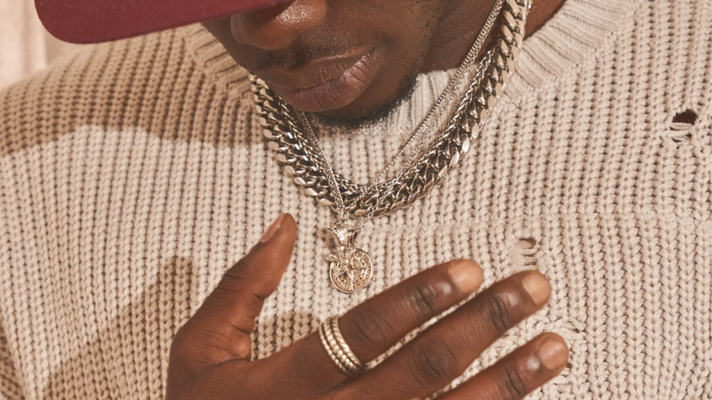 Man wearing red hat, white jumper and Silver Cuban Link Chain with matching rings