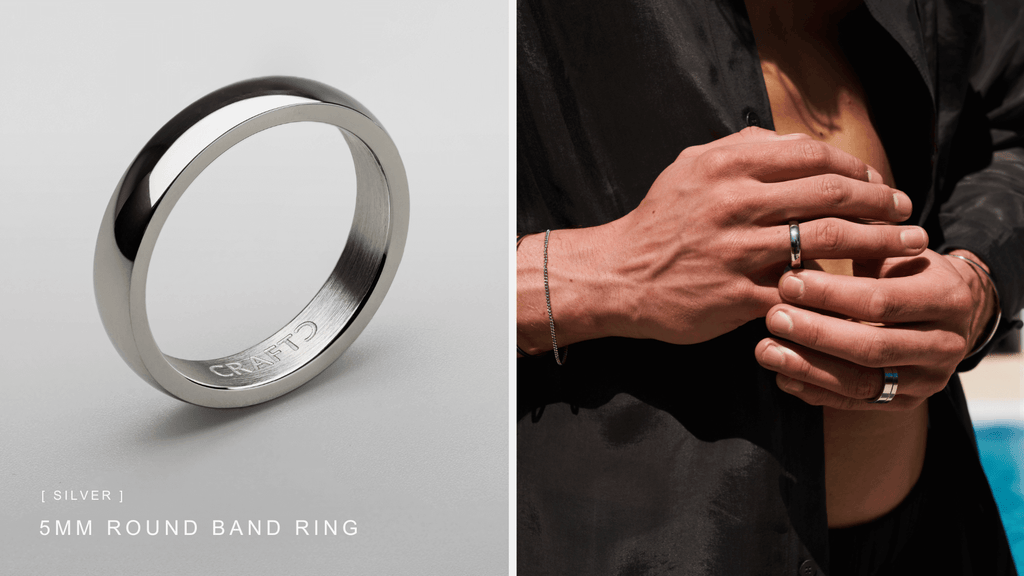 Man in an open black shirt holding his hands and wearing a sleek round band ring in silver