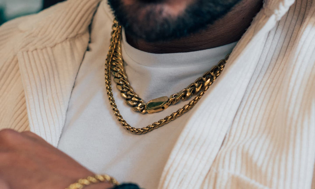 Man wearing a white t-shirt, white ribbed shirt, and an 18K Gold Cuban Link Chain