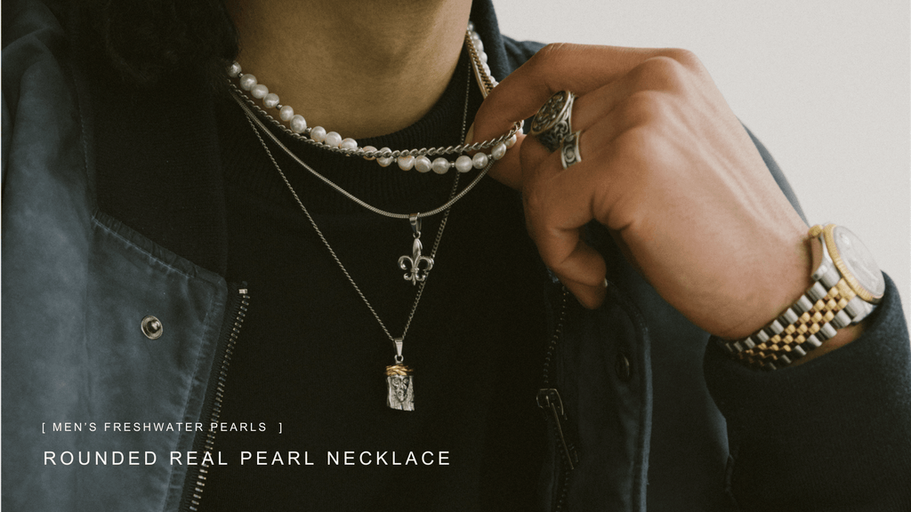 Up close shot of mans wearing a silver watch, chain, pearls and rings