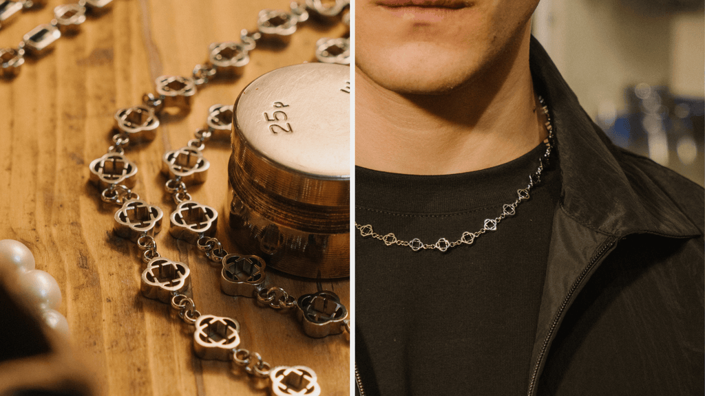 Up close product shot of a man's silver clover necklace and chain