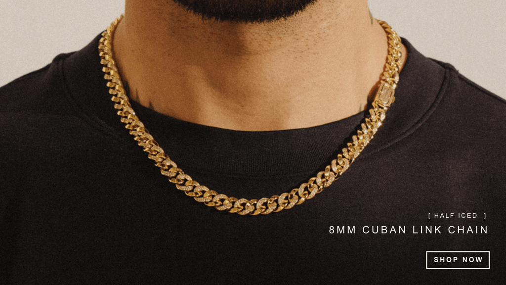 Man wearing a plain black t-shirt and styling an ICED-out cuban link chain in gold