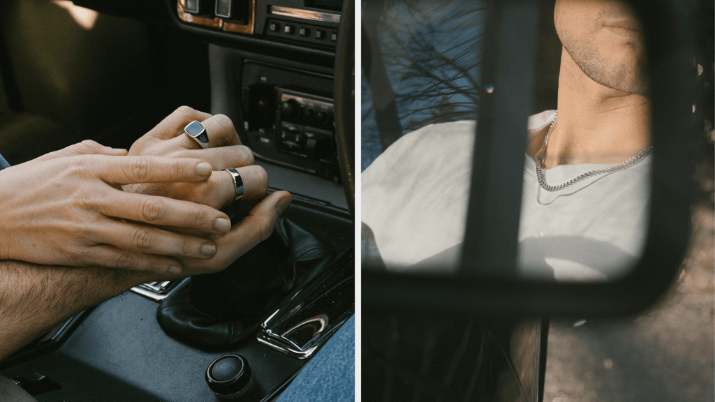 Man's hand resting on a car gear stick whilst wearing a Sterling Silver Ring. Woman's hand resting on top of his. You can also see him wearing a Cuban Link Chain from the side mirror of the classic car