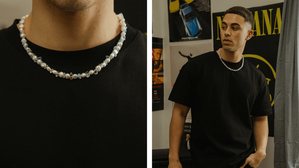 Man wearing a plain black t-shirt and wearing a contrasting set of men's pearl necklaces