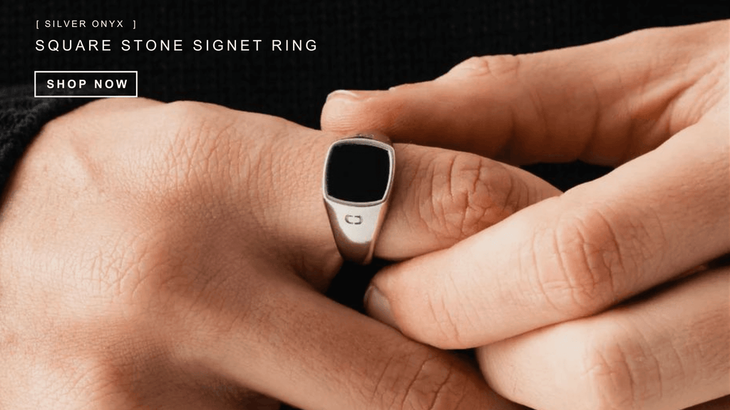 Up close look at a man's hand and the silver signet ring he is wearing on his third finger. The Signet ring is square in shape and has an onyx stone at it's center