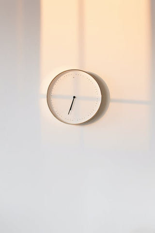 Image d’une horloge murale analogique blanche sur un mur blanc