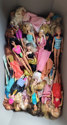 large storage bin filled with well-loved barbie dolls