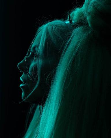 Gothic model profile portrait wearing a headdress with chains and spike headband.