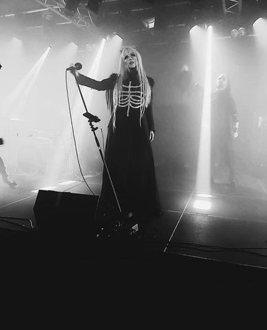 Singer of Frayle on stage performing in gothic skeleton dress with a costume spiky headpiece.