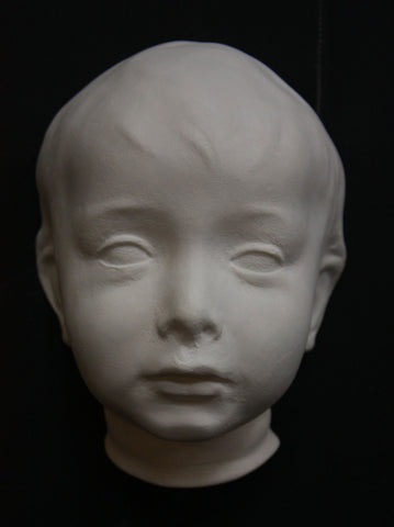 photo of plaster cast of boy's head on black background