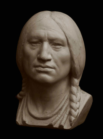 Photo with black background of plaster cast bust of male with braids
