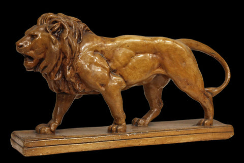 Photo of an original Caproni plaster cast of a walking lion on a black background
