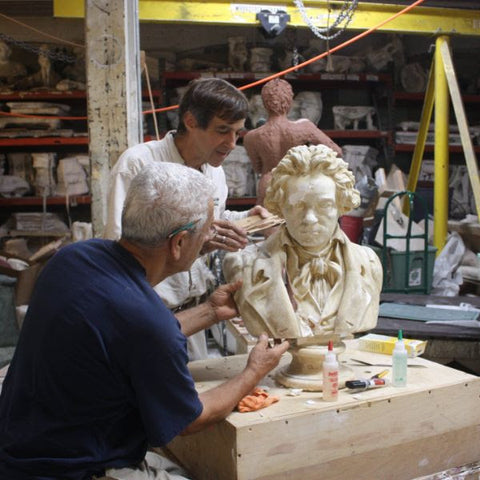 photo of two men working on yellowed, damaged plaster cast sculpture bust of Hagen's Beethoven