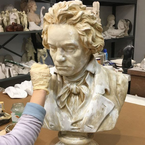 photo of artist's arm and hand painting plaster cast sculpture bust of Hagen's Beethoven