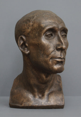 photo of plaster cast sculpture bust of man, namely Niccolo da Uzzano, in Bronze Patina on a gray background