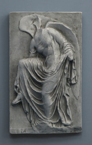 photo of cast of sculpture relief of robed figure, head now missing, reaching for her sandal in Dark Stone Patina on a dark gray background