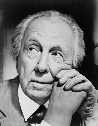 black and white portrait photo of Frank Lloyd Wright with hands clasped at cheek