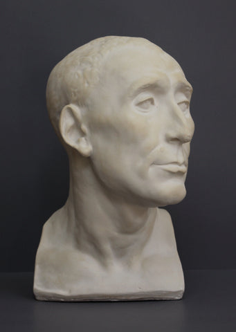photo of plaster cast sculpture bust of man, namely Niccolo da Uzzano, in Sandstone Patina on a dark gray background