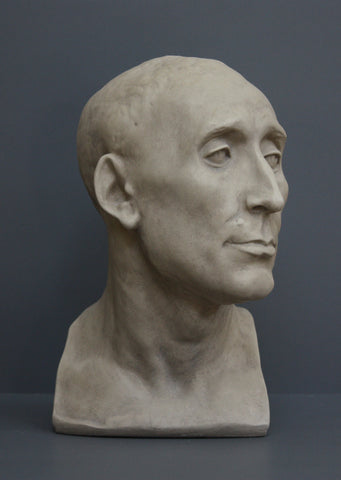 photo of plaster cast sculpture bust of man, namely Niccolo da Uzzano, in Stone Patina on a dark gray background