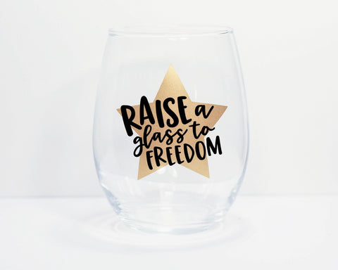 Photo of stemless wine glass with decal of gold star with lyrics in black