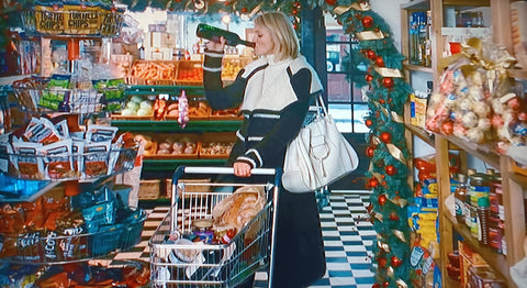 The Holiday still - Cameron Diaz carries big cream bag in food shop, drinking wine