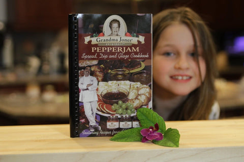 Lauren Jones in front of the "Grandma Jones' Originals Cookbook"