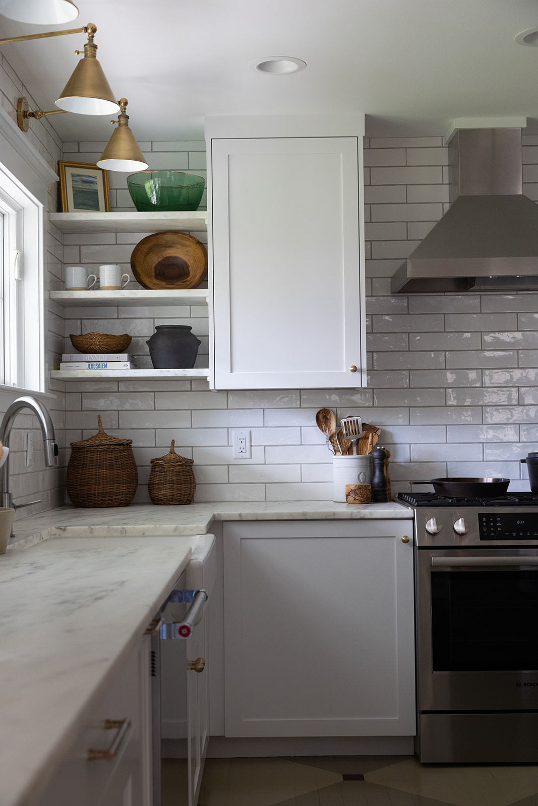 White kitchen with corner shelves and wicker baskets and wood bowls